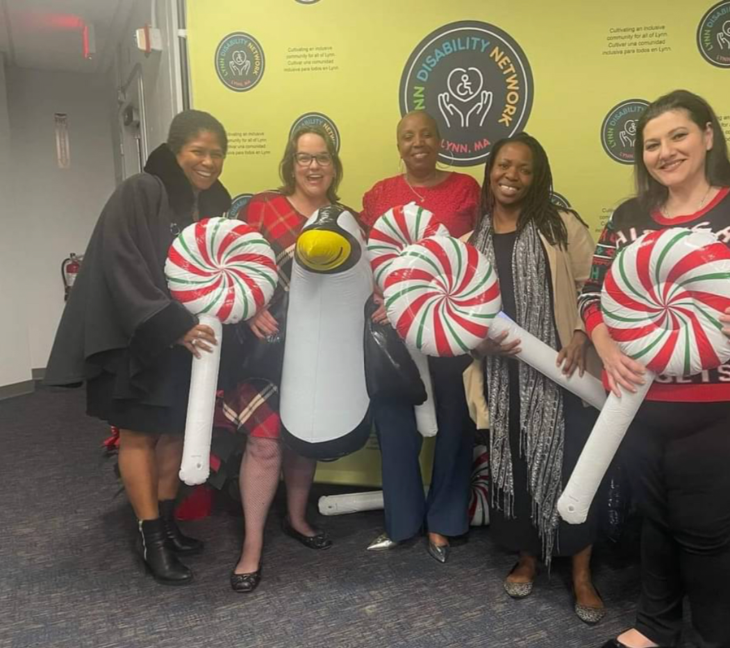 a group of people posing for a picture with candy canes in front of an LDN logo wall